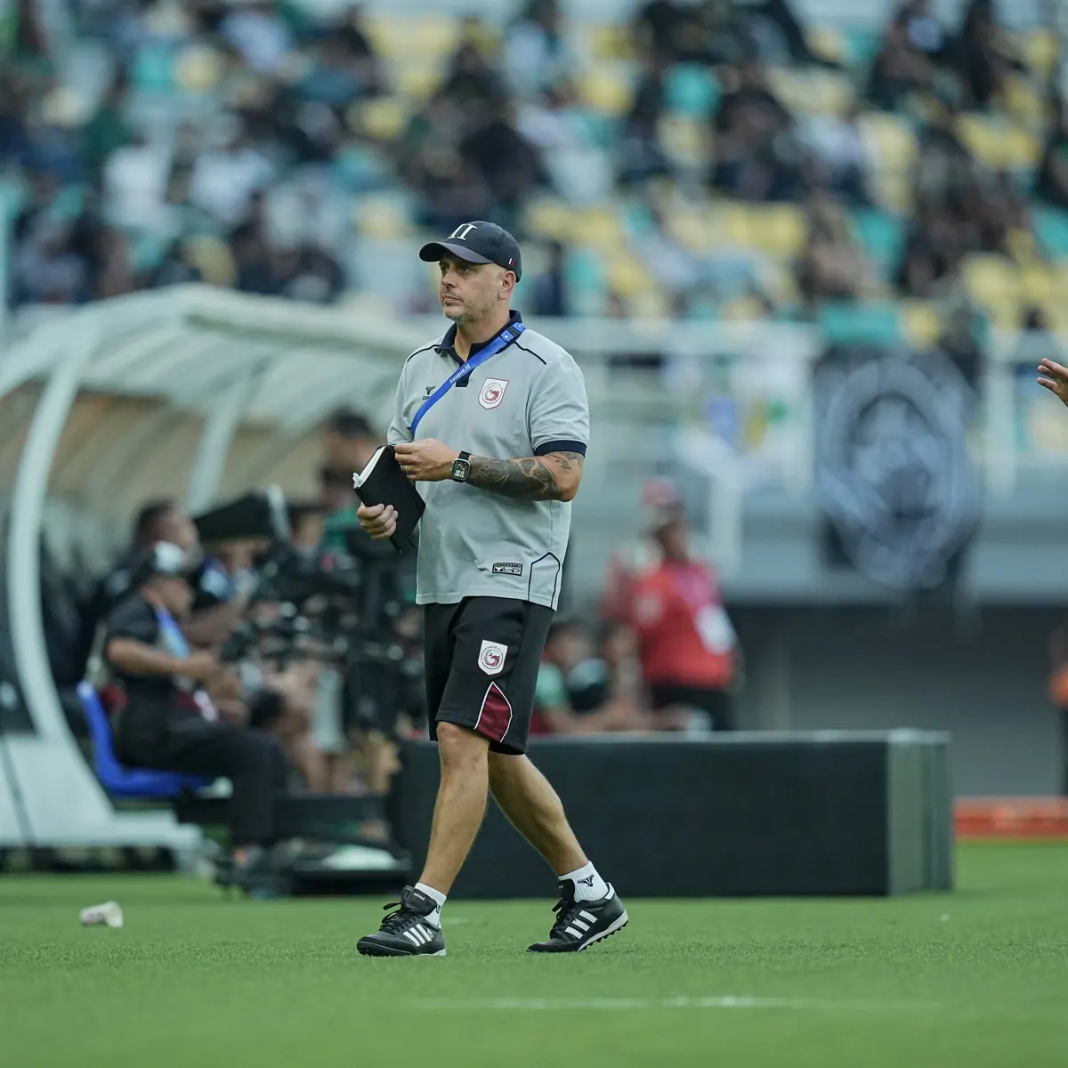 John Wall walking along the touchline with a notebook during a Garudayaksa FC match