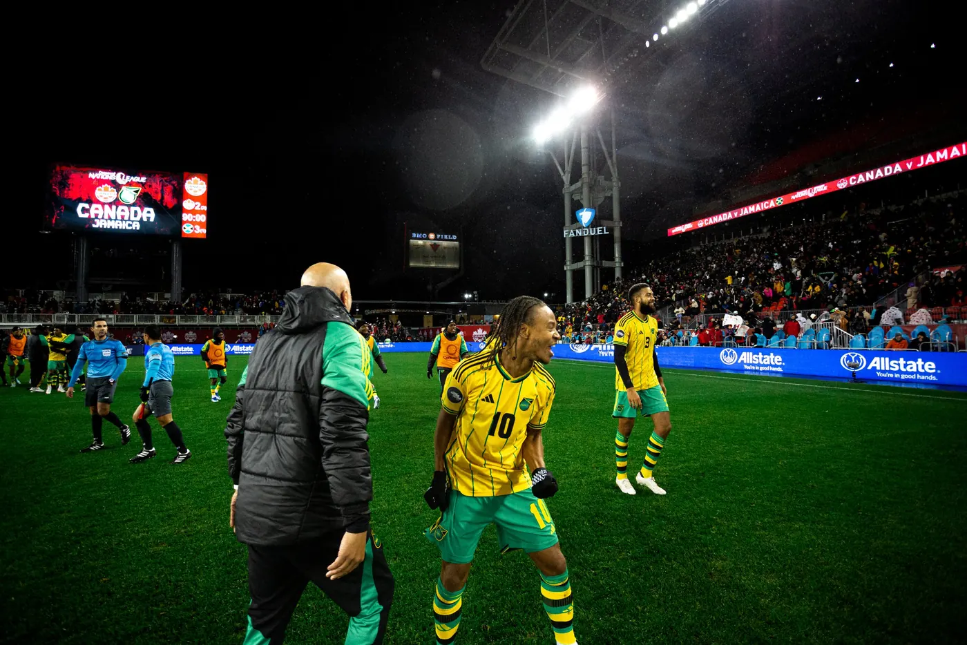 John Wall celebrating with Jamaica players on the pitch after a night match in Toronto