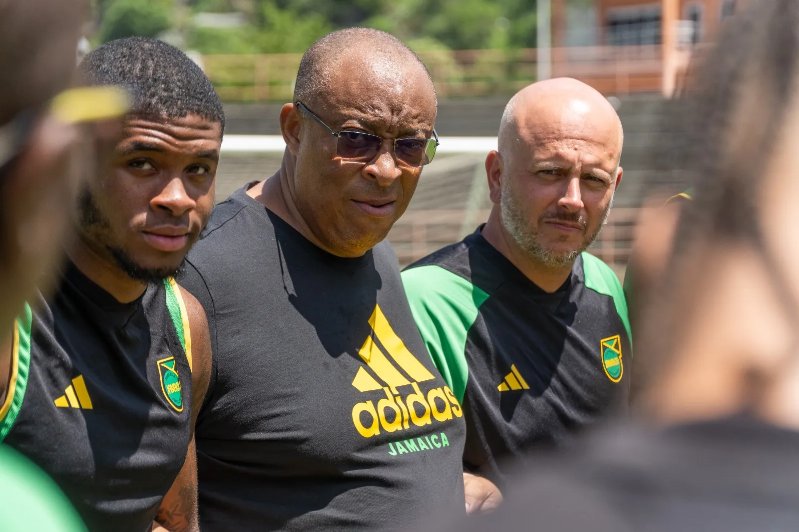 John Wall listening in a team huddle with Jamaica players and staff during a national team camp