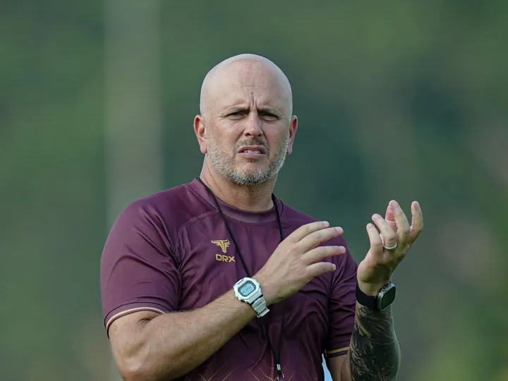 John Wall coaching at a Garudayaksa FC training session, gesturing with both hands